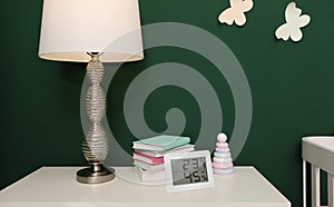 Digital hygrometer with thermometer on white table in children`s room. Optimal humidity level for kids