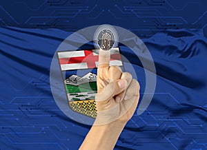 Digital ID Alberta on finger of white skin person and Canadian province flag on background