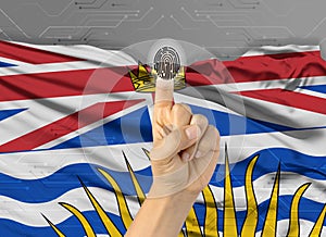 Digital ID British Columbia on finger of white skin person and Canadian province flag on background