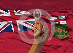 Digital ID Manitoba, finger of dark skin person and Canadian province flag on background