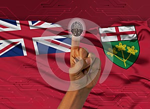 Digital ID  Ontario on finger of white skin person and Canadian province flag on background
