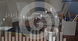 Digital image of graphs moving in the screen with a background of a work space with a cup of coffee,