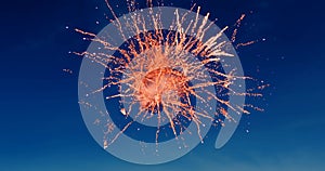 Digital image of red fireworks exploding in the blue sky