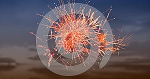 Digital image of red fireworks exploding in the sky with clouds during sunset