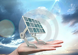 Digital image of solar panel on hand against sky