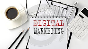 DIGITAL MARKETING text on the paper with calculator, notepad, coffee ,pen with graph
