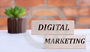 DIGITAL MARKETING the words on cubes against the background of a brick wall with a cactus