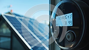 A digital meter with a blue LED display shows numerical readings, mounted on a wall. photo