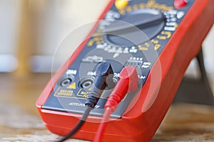 Digital multimeter with connected probes on a wooden table