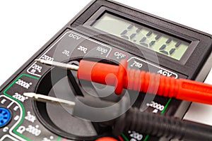 Digital multimeter with probes on a white background