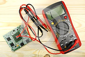 Digital multimeter with probes on a wooden table