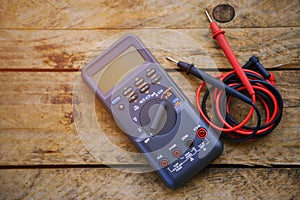 Digital multimeter and wiring on wooden table. special tools of technician for work with circuit and electrical.