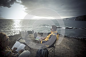 Digital nomad and freedom from office work lifestyle - couple of traveler enjoying the outdoor working activity on the cliff