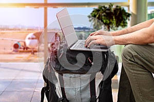 digital nomad sitting alone and typing on his laptop