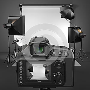 Digital photo camera in studio with softbox and flashes.