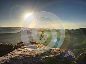 Digital photo camera with tripod  record video during sunrise