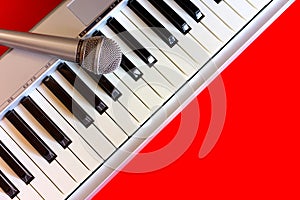 Digital piano with microphone on red bacground
