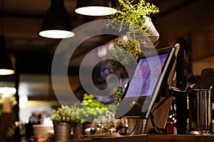 Digital POS register system in restaurant with plants