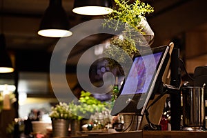 Digital POS register system in restaurant with plants photo