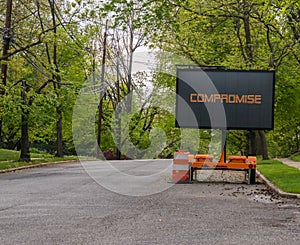 Digital road sign on a residential street that says, compromise.