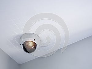 Digital security eye. A white round indoor CCTV surveillance camera.