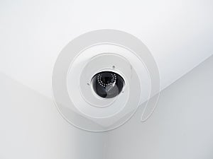 Digital security eye. A white round indoor CCTV surveillance camera.