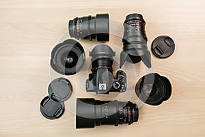 Digital SLR camera and a few interchangeable manual lenses. The equipment for filmmaking. The wooden table