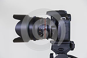 Digital SLR camera with interchangeable manual lens on a gray background. Shooting in the interior. The equipment for filmmaking