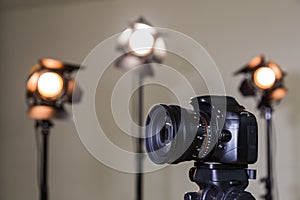 Digital SLR camera and three spotlights with Fresnel lenses. Manual interchangeable lens for filming