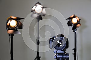 Digital SLR camera and three spotlights with Fresnel lenses. Manual interchangeable lens for filming