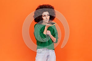 Digital speaker app. Portrait of woman with Afro hairstyle in green sweater talking to mobile phone