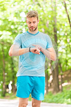 A digital sports watch. Athletic man tracking training with watch on hand. Handsome athlete using smart watch during