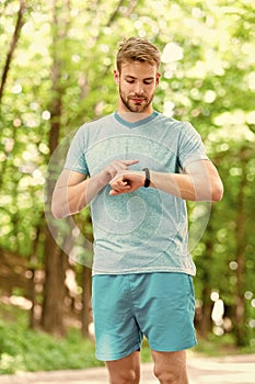 A digital sports watch. Athletic man tracking training with watch on hand. Handsome athlete using smart watch during