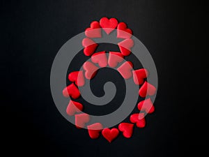 Digital symbol 8, laid out with red silk hearts on a black background. March 8. International Women's Day