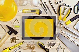 Digital Tablet and Assorted Carpentry Tools on Workshop Table