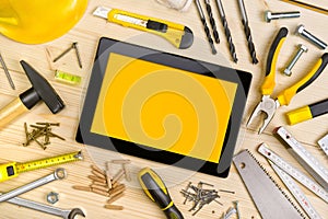 Digital Tablet and Assorted Carpentry Tools on Workshop Table