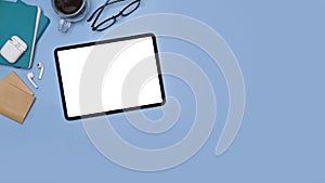 Tablet with blank screen, sticky notes and coffee cup on blue background.