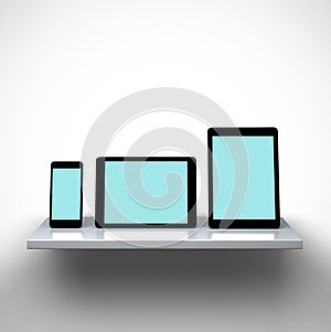 Digital tablet computers and smart phone on a shelf