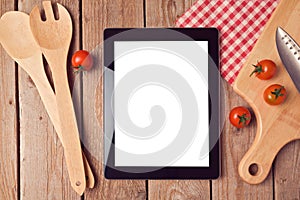 Digital tablet mock up template with cooking utensils and tomatoes. View from above