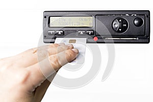 Digital tachograph and drivers hand inserting drivers card in it. No personal data. Isolated on white background