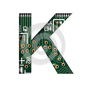 Digital technology font. The letter K cut out of white on the printed digital circuit board with microprocessors and