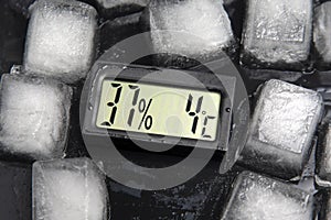 Digital thermometer for measuring air temperature and humidity against the background of frozen ice