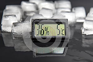 Digital thermometer for measuring air temperature and humidity against the background of frozen ice