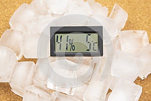 Digital thermometer for measuring air temperature and humidity against the background of frozen ice