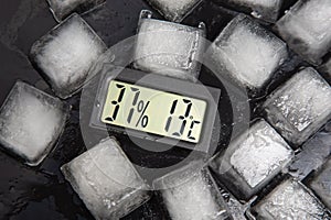 Digital thermometer for measuring air temperature and humidity against the background of frozen ice