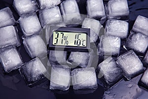 digital thermometer for measuring air temperature and humidity against the background of frozen ice