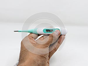 a digital thermometer with temperature reading in fahrenheit in the hands of a person