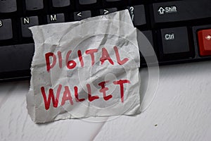 Digital Wallet write on crunched paper isolated on wooden table photo