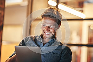 Digitalize tasks to save time. a handsome young man working late in his office.