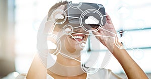 Digitally generated image of cloud computing icons with woman using VR glasses in office